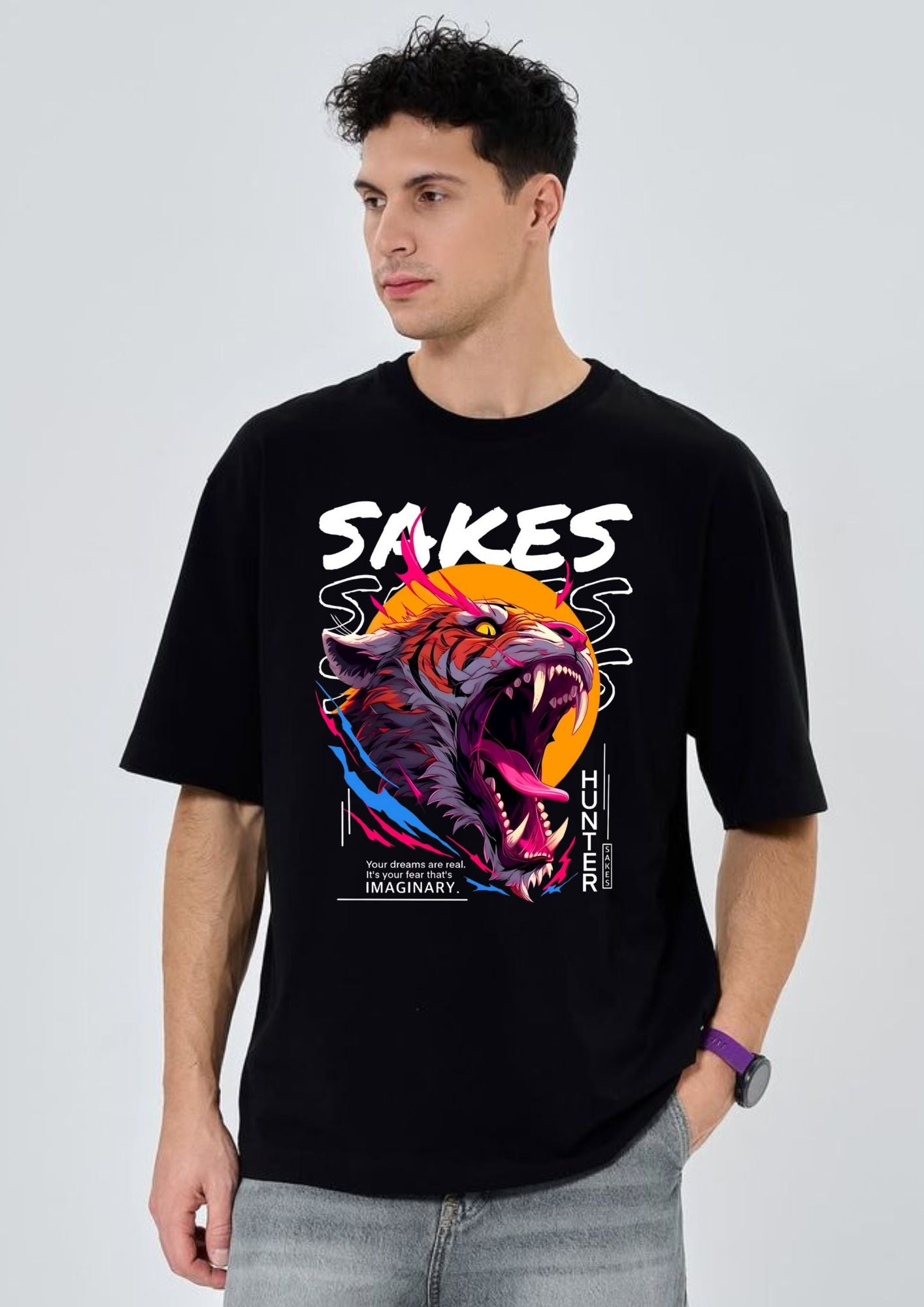 Man wearing a black t-shirt with a colorful graphic design on a light gray background